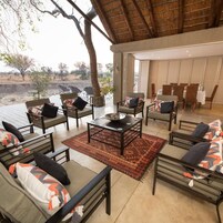 Un espacio exterior con sofás y sillones, una mesa de centro y vistas al paisaje.