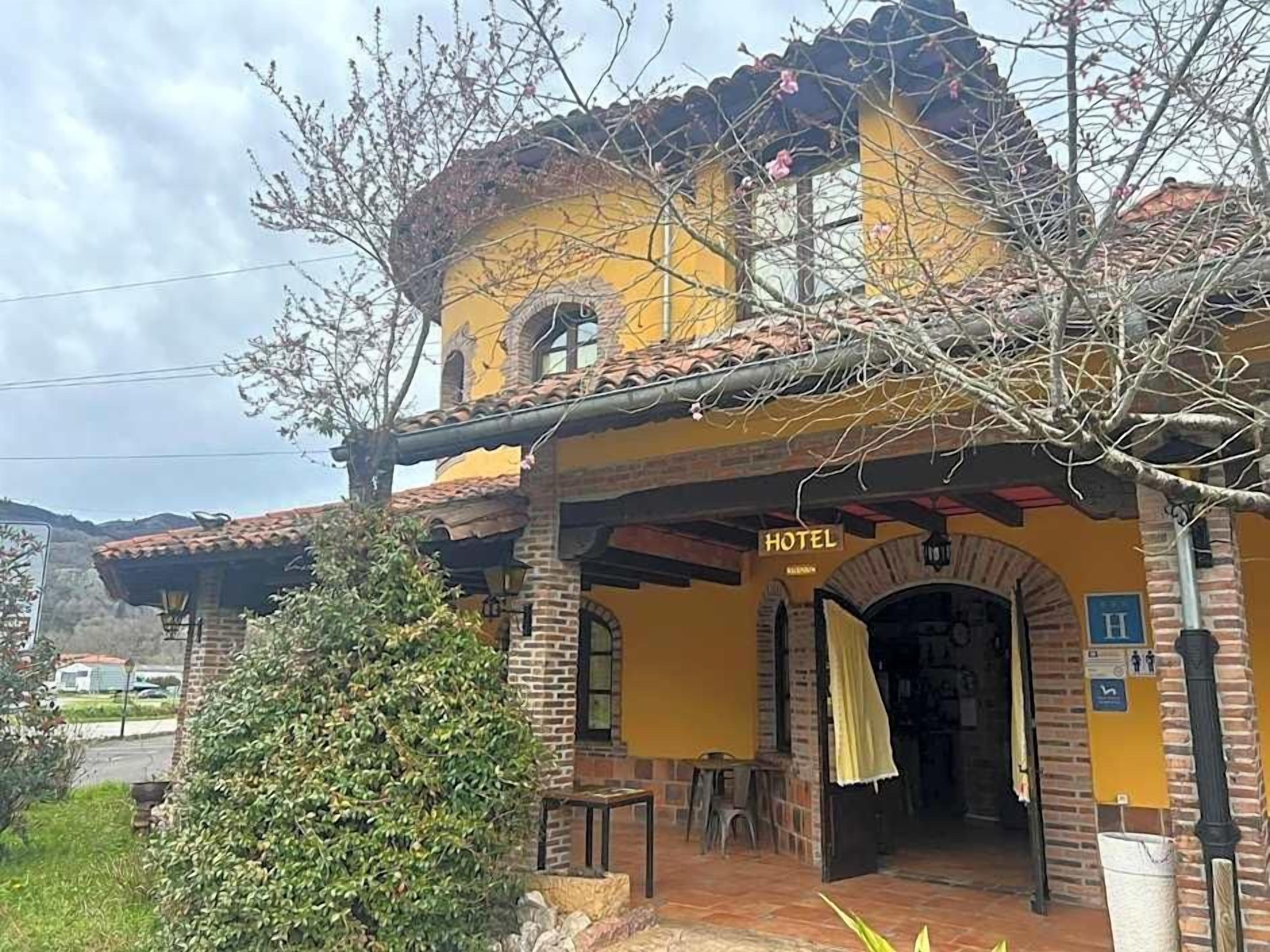 Un edificio amarillo con un letrero que dice 'HOTEL' sobre la entrada.