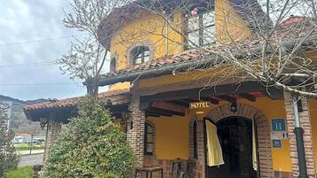 Un edificio amarillo con un letrero que dice 'HOTEL' sobre la entrada.