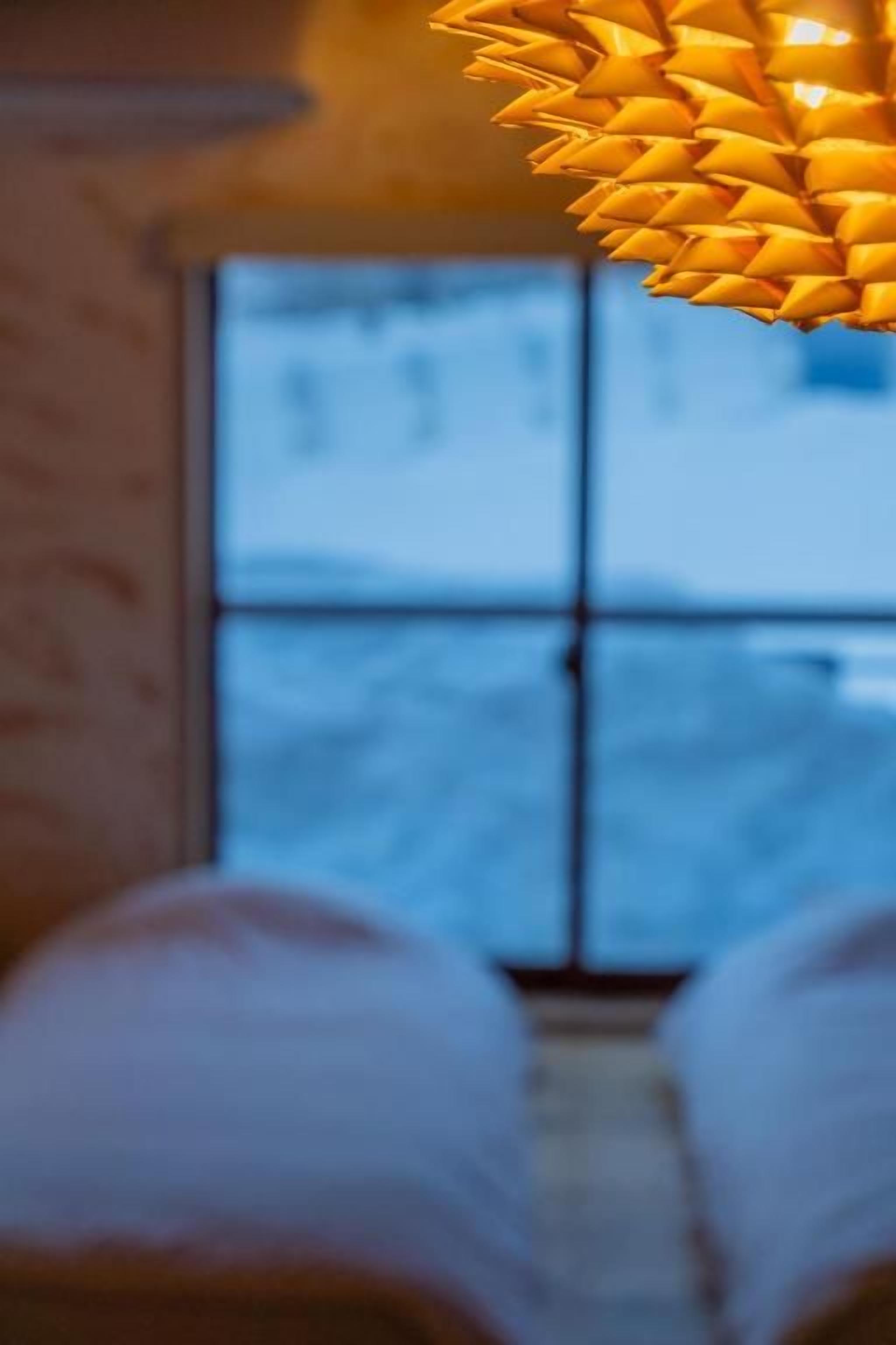 A bed with a view of a snowy landscape through a window.