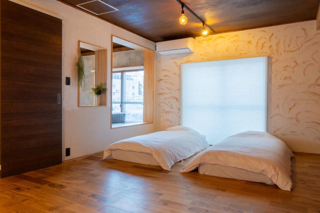 A room with a bed, a window, and a mirror.