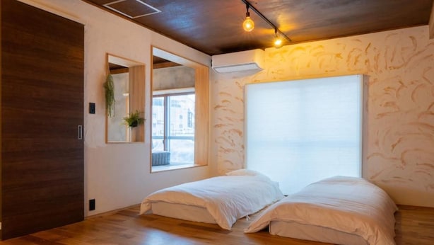 Una stanza con un letto, una finestra e uno specchio.