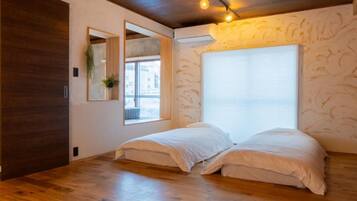 A room with a bed, a window, and a mirror.