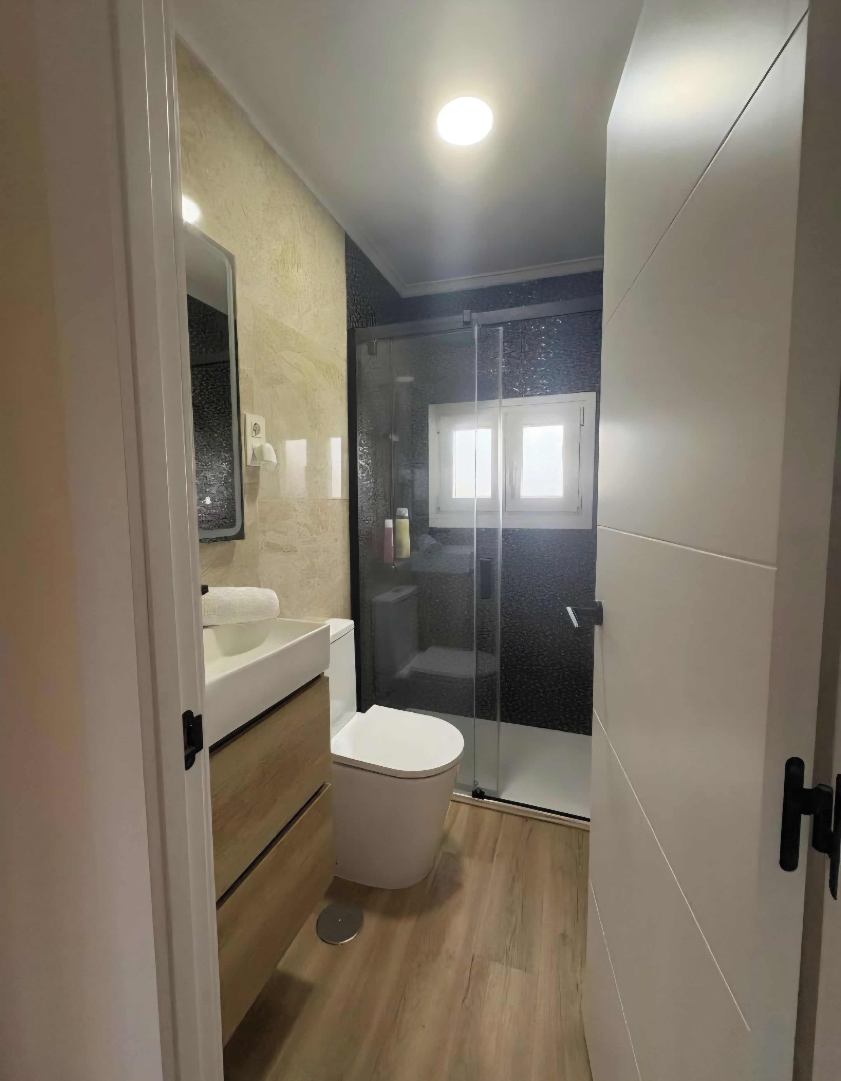 A modern bathroom with a toilet, sink, and shower area.
