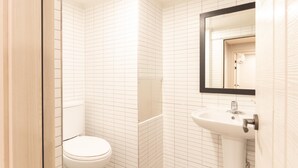 Ein Badezimmer mit Toilette, Waschbecken und Spiegel.