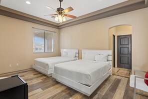 A bedroom with two beds, a ceiling fan, a window with blinds, and a door. - Mountain View Estate w/ Heated Pool, Spa & Slide (Mesa)