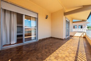A balcony with a tiled floor, a sliding glass door, and a small outdoor seating area. - 340 m2 Romantic Portugal independent house 5 min. from the sand beach and ocean. (Cascais)