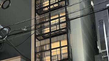 A hotel entrance with a modern design, featuring a glass facade and a signboard.