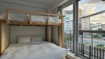 A bunk bed with a view of a cityscape through a large window.
