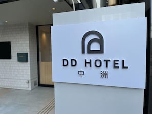 A sign for DD Hotel with a modern design, featuring a logo and name in both English and Chinese. - Riverside Hostel Yurariver Susaki (Fukuoka)