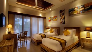 A hotel room with two beds, a desk, a chair, and artwork on the walls.