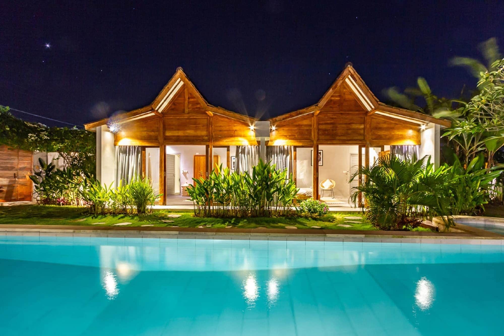 A two-story wooden building with a swimming pool in front.