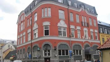 A multi-story building with a red facade, arched windows, and a corner entrance.