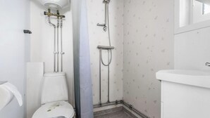 Un baño con inodoro, ducha y lavamanos.