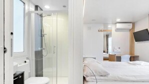 Un baño moderno con cabina de ducha de vidrio, inodoro y lavabo.