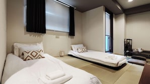 Habitació d'hotel amb dos llits, una taula i una cadira.
