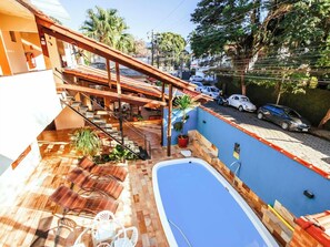 A residential property with a swimming pool, outdoor seating, and a staircase leading to a covered area. - Velinn HPJ Ilhabela Hostel (Ilhabela)