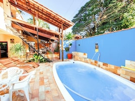Piscina con cubierta de madera, asientos al aire libre y una escalera que lleva a un nivel superior.