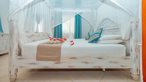 A four-poster canopy bed with a white headboard, a beige bedspread, and blue and white striped pillows. - Twiga Beach Clubviaggi Resort Watamu (Watamu)