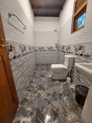 A bathroom with a toilet, bidet, and a shower area. - Senlora Resort (Tangalle)