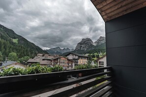 A balcony overlooking a mountainous landscape with traditional buildings. - Hotel Ciasa Soleil (Badia)