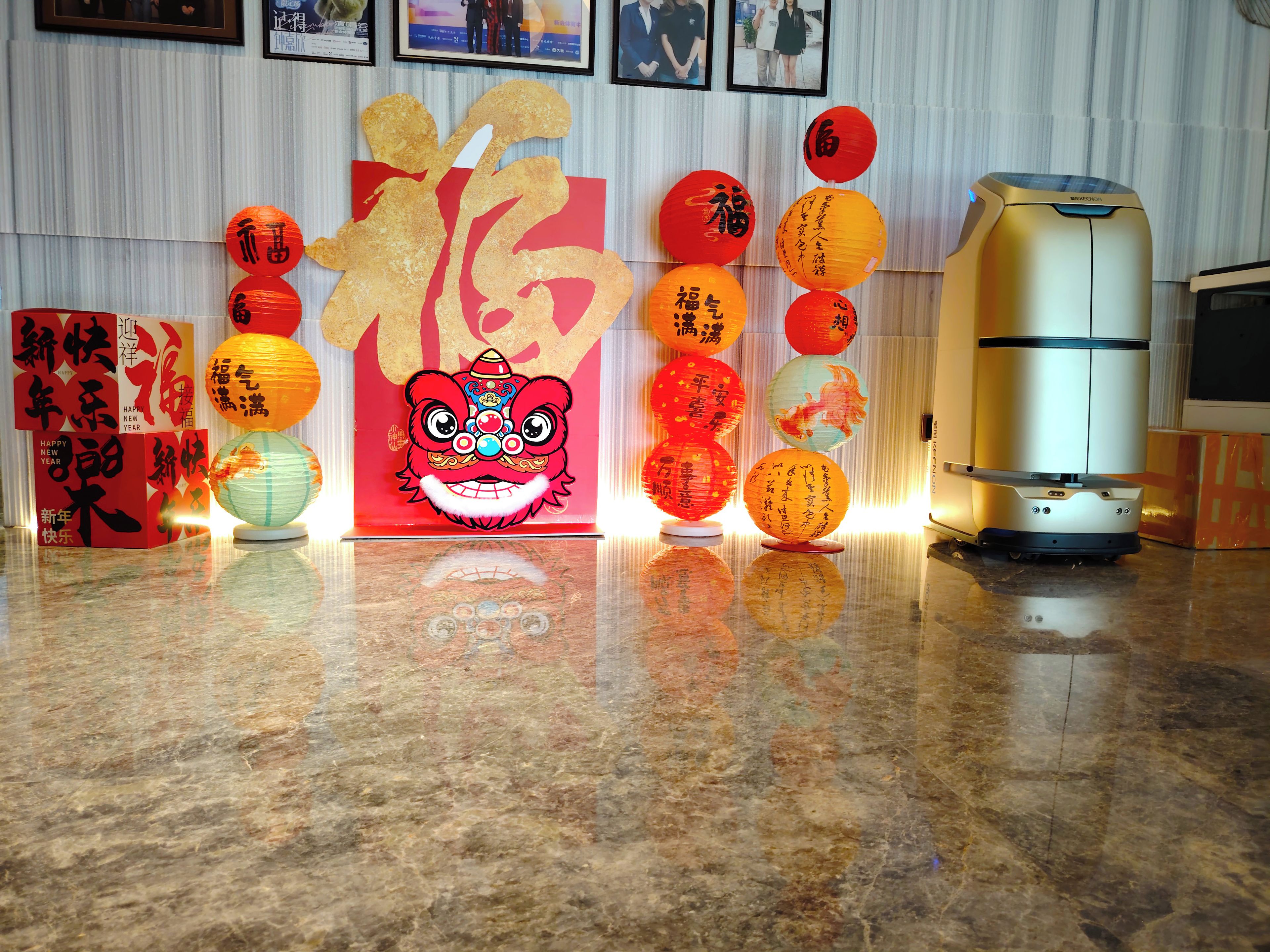 A room with a red decorative backdrop, a lion dance head, and several traditional lanterns.
