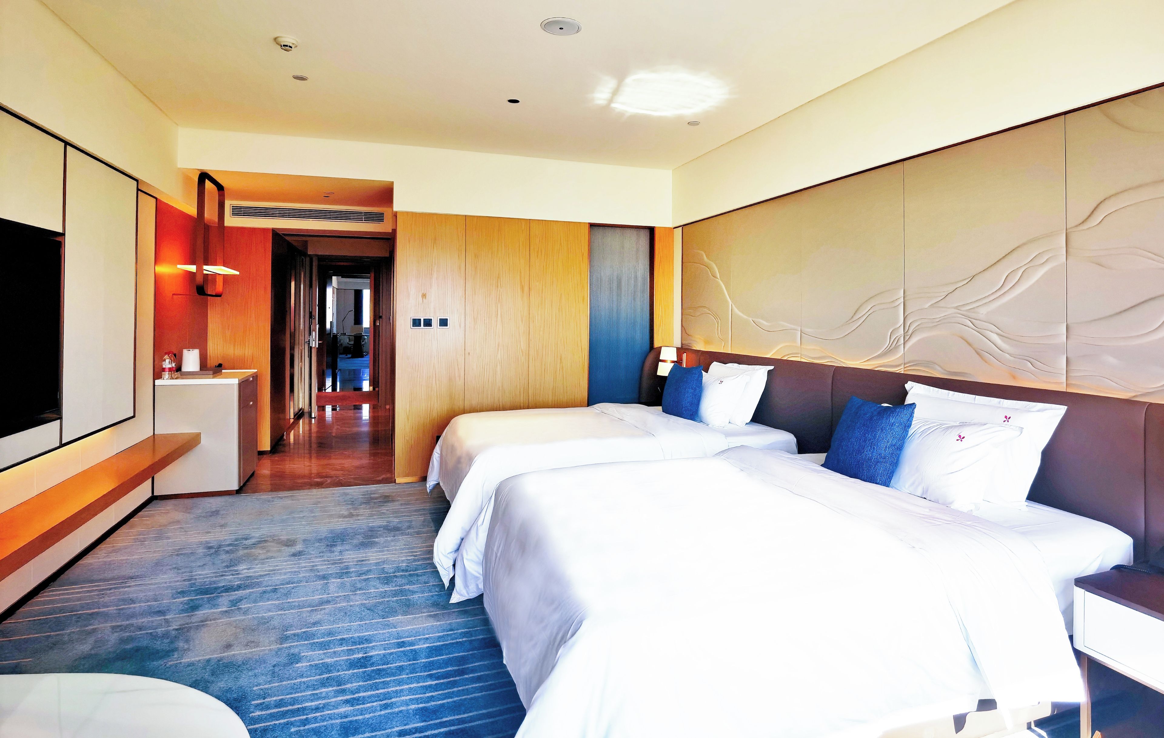 Una habitación de hotel con una cama grande, un escritorio y un televisor.