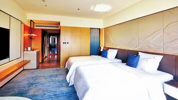 Una habitación de hotel con una cama grande, un escritorio y un televisor.