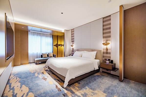 A hotel room with a large bed, bedside tables, a TV, and a window with curtains. - Flower Season Hotel (Jiangmen)