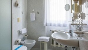 Un bany modern amb vàter, bidet, rentamics i banyera.
