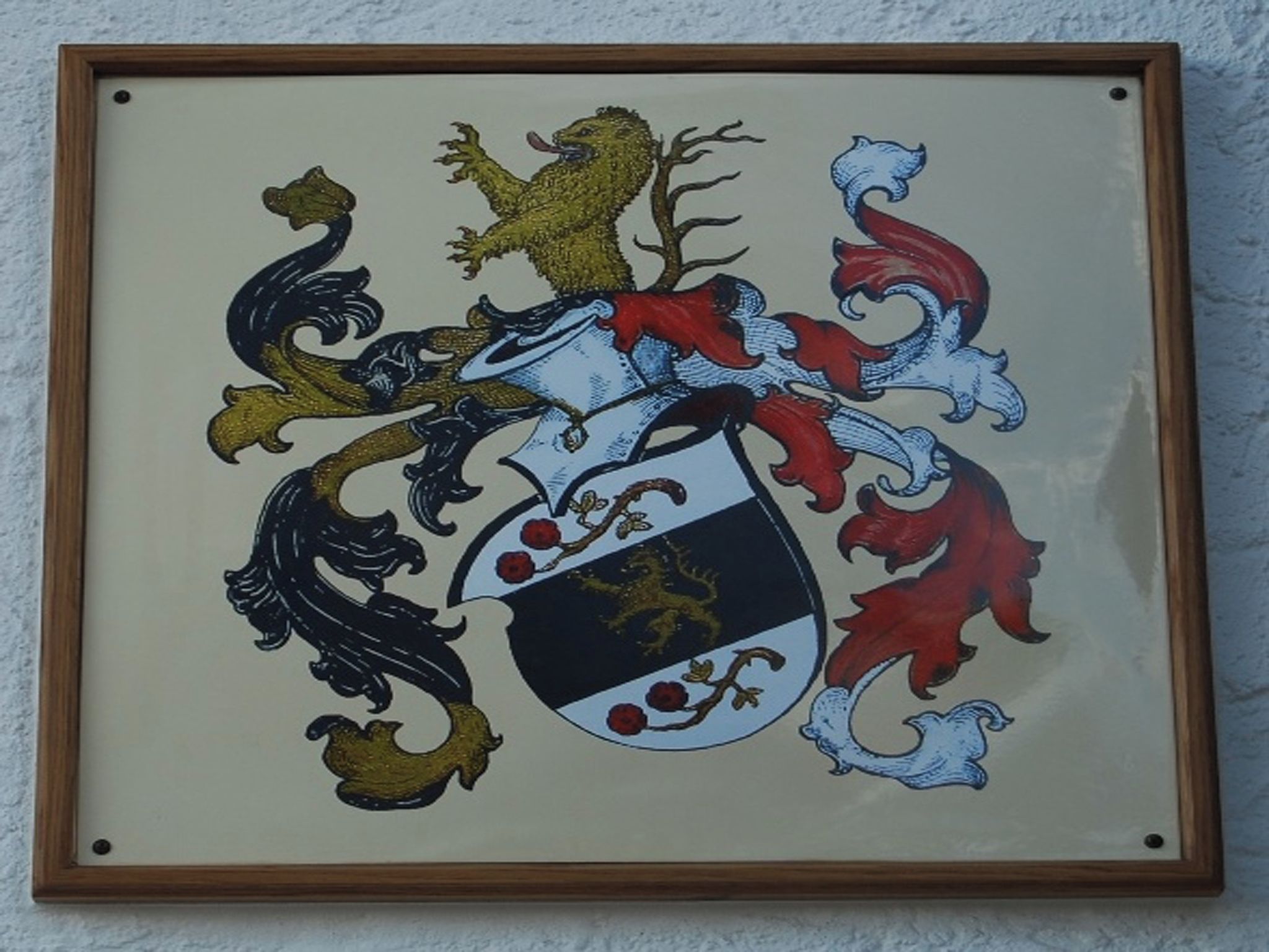 A framed coat of arms with a shield, lions, and a horse.