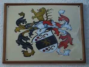 Un blason encadré, comprenant un écu, des lions et un cheval.