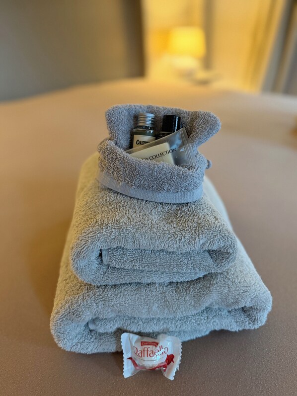 A folded towel with a bottle and a packet of Daffa ice cream.