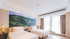A hotel room with two beds, a large window with curtains, a wall-mounted painting of a landscape, and a ceiling vent. - Atour Hotel (Lianyungang)