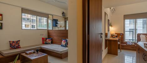 A modern living room with a sofa, coffee table, and a dining area with a table and chairs.