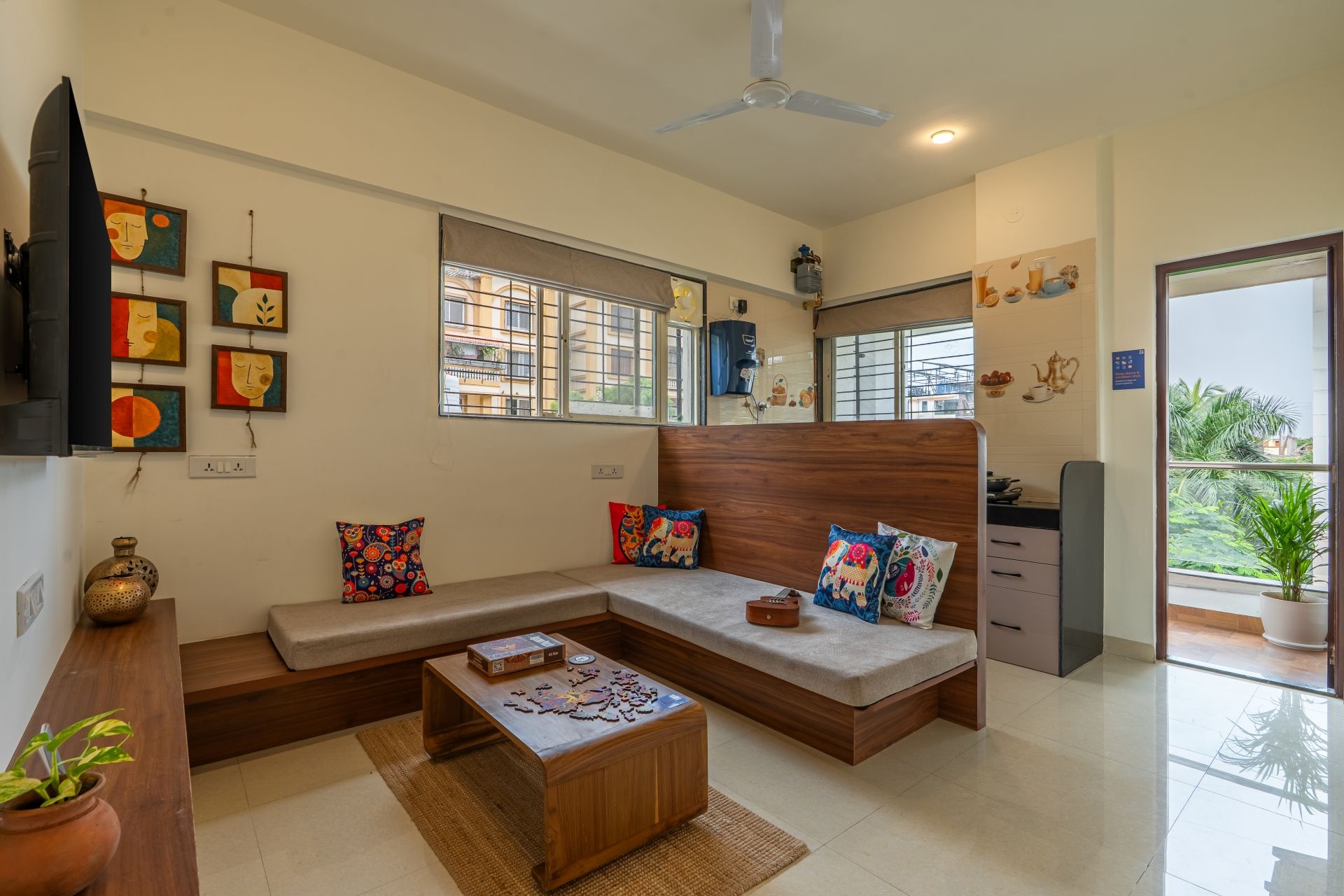 A modern living room with a sectional sofa, a coffee table, and artwork on the walls.