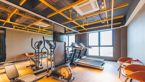 Un gimnasio moderno con cintas de correr, bicicletas estáticas y elípticas.