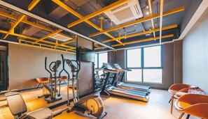 A modern gym with treadmills, stationary bikes, and elliptical machines. - Atour Hotel (Zhenjiang)