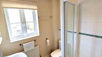 A bathroom with a toilet, sink, and shower area.