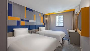 A hotel room with two beds, a desk, a window, and a modern wall design.