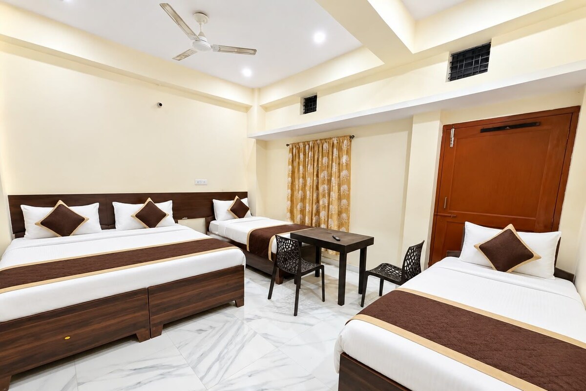 A hotel room with two beds, a desk, and a chair.