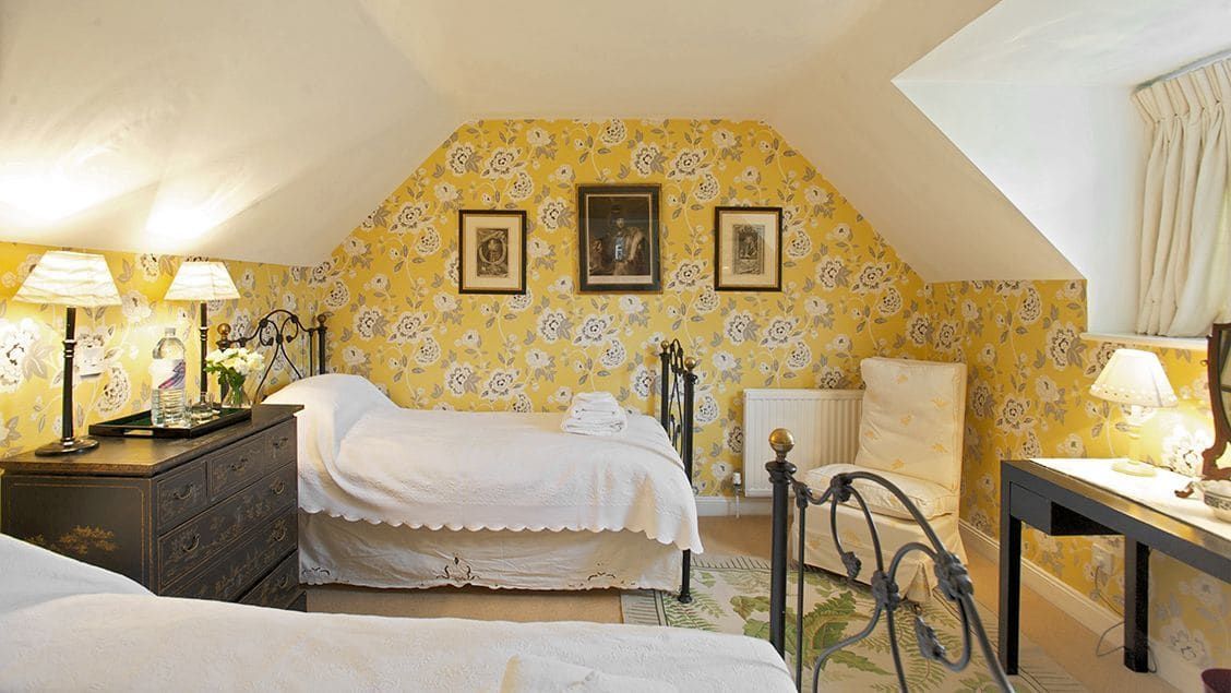 A bedroom with a bed, bedside tables, lamps, and a radiator.
