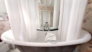 A bathroom with a freestanding bathtub, a mirror, and a towel rack. - Saratoga Cottage (Chipping Norton)