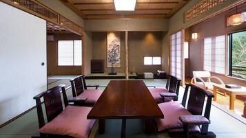 Una habitación japonesa tradicional con suelo de tatami, una mesa baja y cojines dispuestos alrededor.