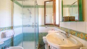 A bathroom with a glass shower enclosure, a sink, a toilet, and a mirror. - Residence Luna Di Ponente (Lampedusa)