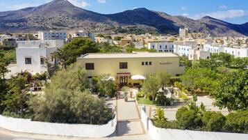 Un hotel con un cortile interno, circondato da edifici, e una montagna sullo sfondo.