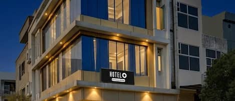 Ein modernes Hotelgebäude mit einem Schild, auf dem 'HOTEL' steht, am Eingang.