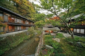 Um edifício japonês tradicional com um caminho que leva a uma construção pequena.