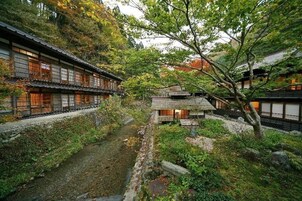 Um edifício japonês tradicional com um caminho que leva a uma construção pequena.
