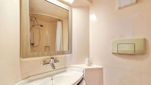 A bathroom with a sink, mirror, shower, and a towel rack.